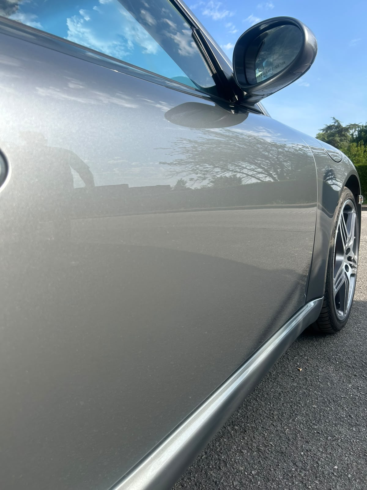 Flanc gris de Porsche avec reflets profonds après céramique