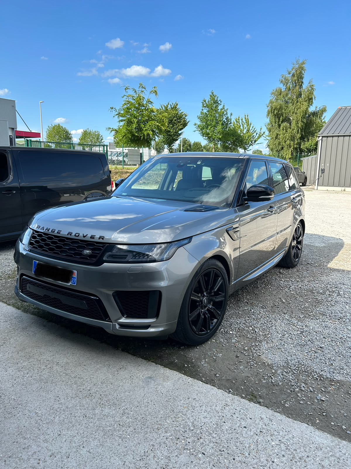 Range Rover Sport grise après lavage complet devant l'atelier