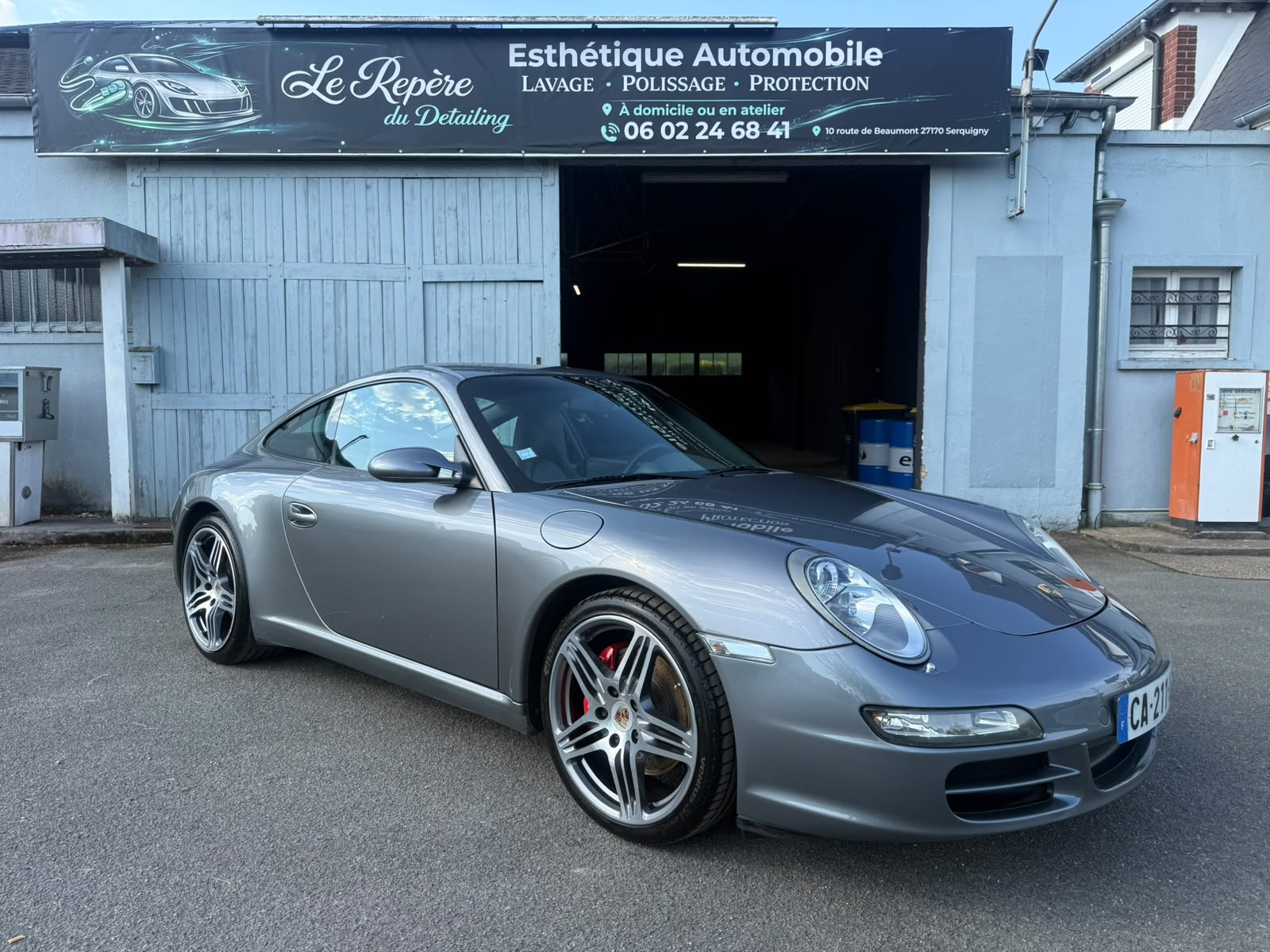 Porsche 911 grise protégée par un traitement céramique devant l'atelier